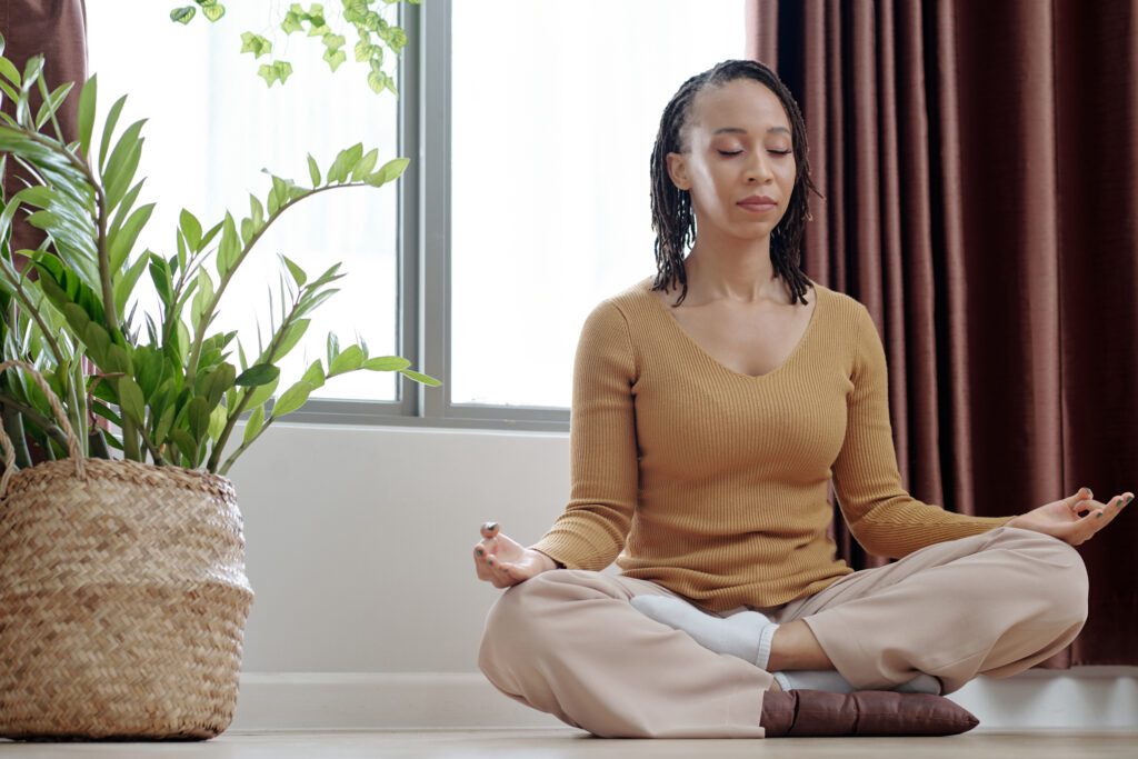 Pretty woman meditating in lotus position  to stay calm and reduce fear during travel