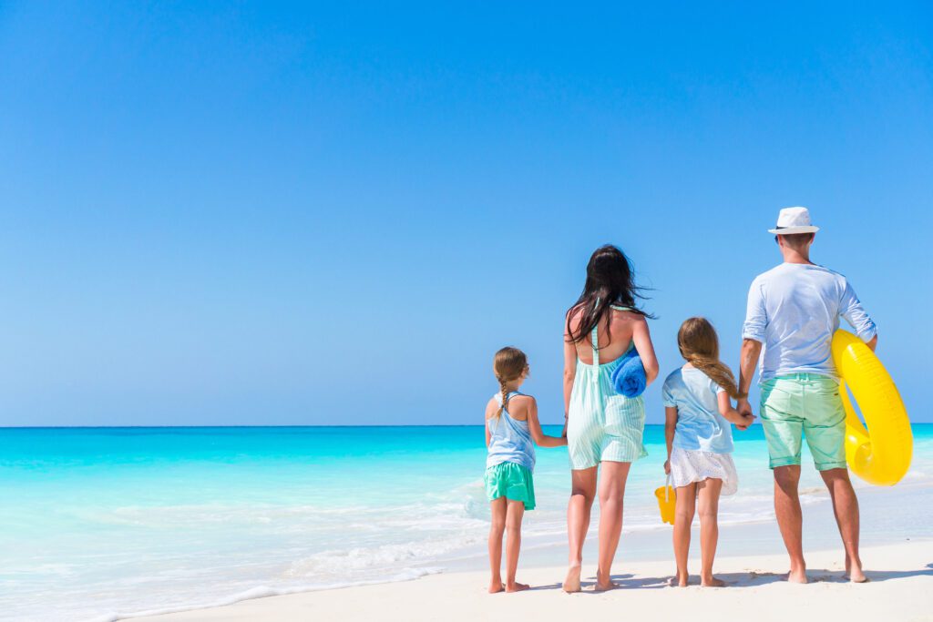 Happy beautiful family on white beach having fun